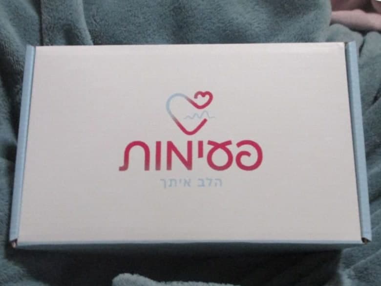 קופסת הערכה הסגורה של פעימות, מונחת על שמיכה רכה